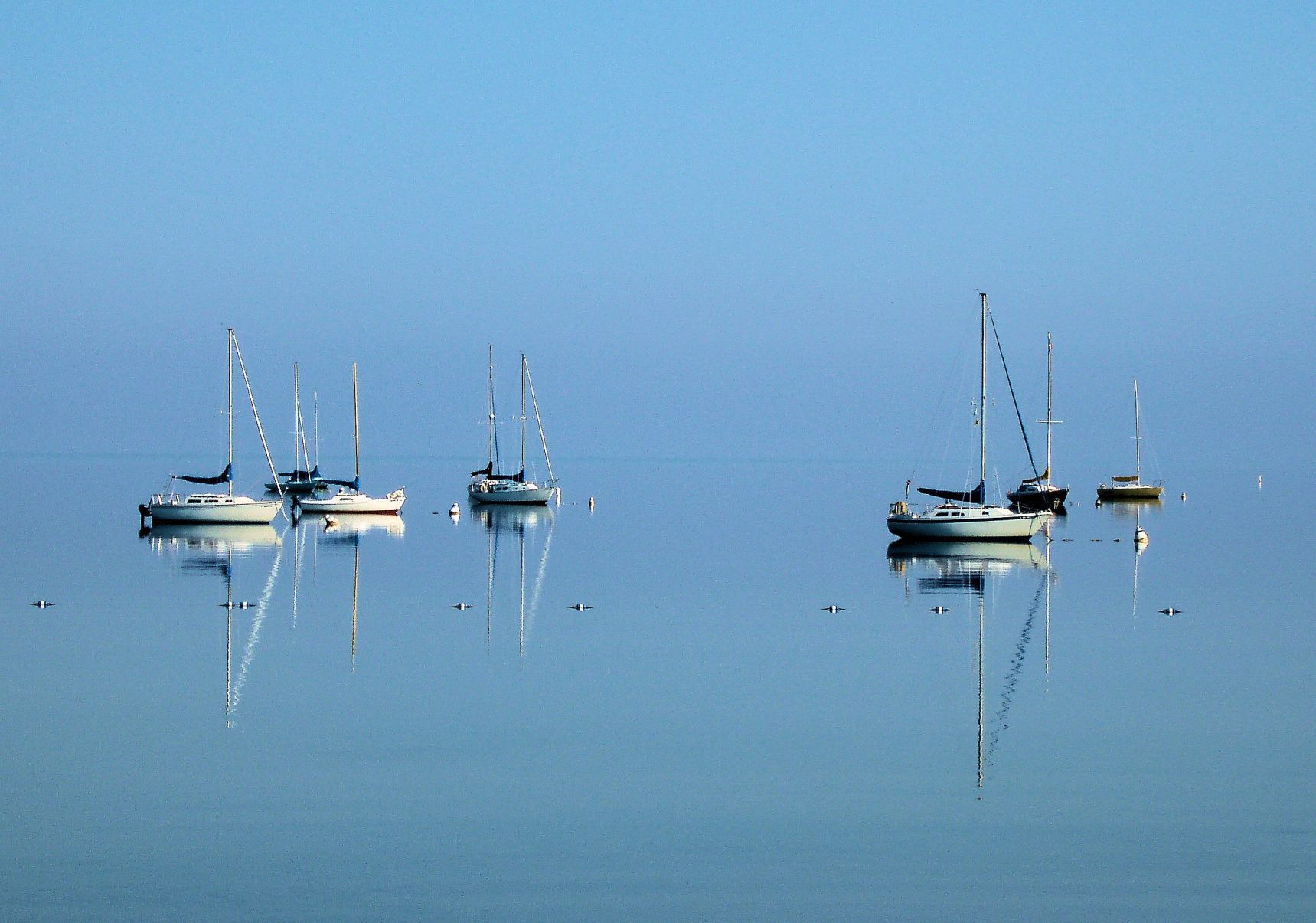 Early morning boats and their reflections on the calm water